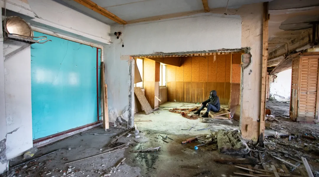 Post apocalyptic survivor in gas mask in a ruined building. Environmental disaster, armageddon concept.